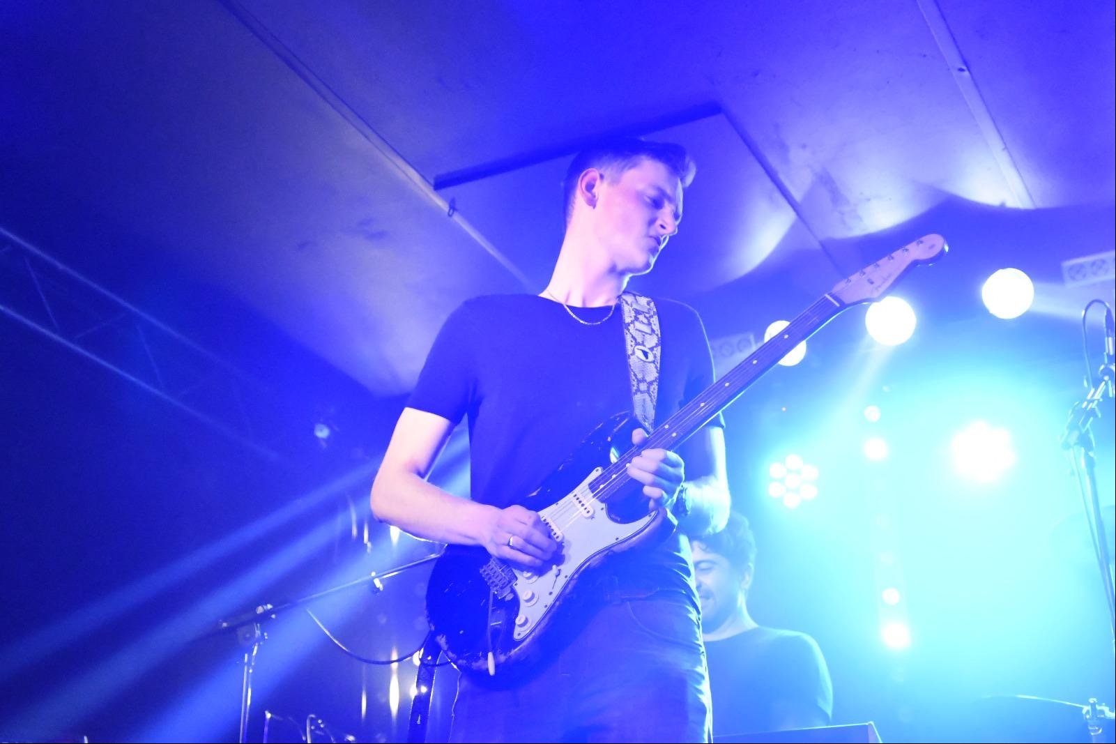 Gerbman playing Stratocaster under blue stage lights
