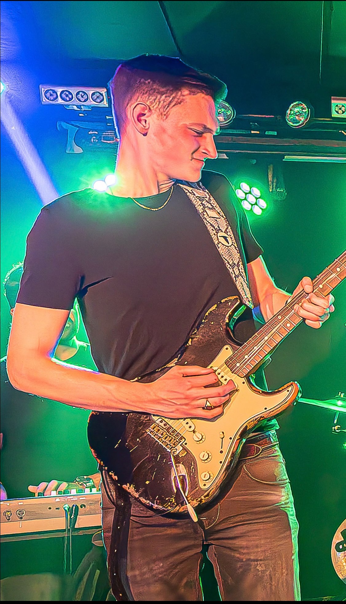 Gerbman on stage with relic Stratocaster, green stage lighting