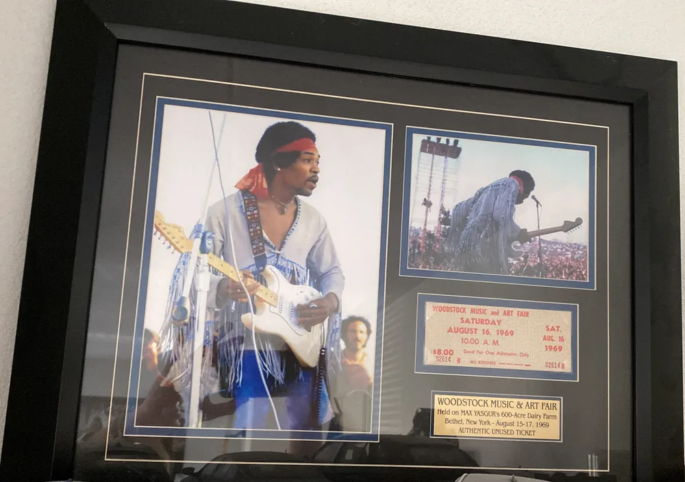 Una entrada enmarcada y sin usar para el sábado 16 de agosto de 1969 en el Woodstock Music & Art Fair, con dos fotos de Jimi Hendrix sobre el escenario
