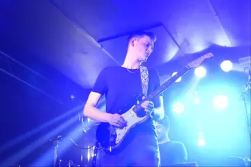 Gerbman spielt Stratocaster unter blauem Bühnenlicht
